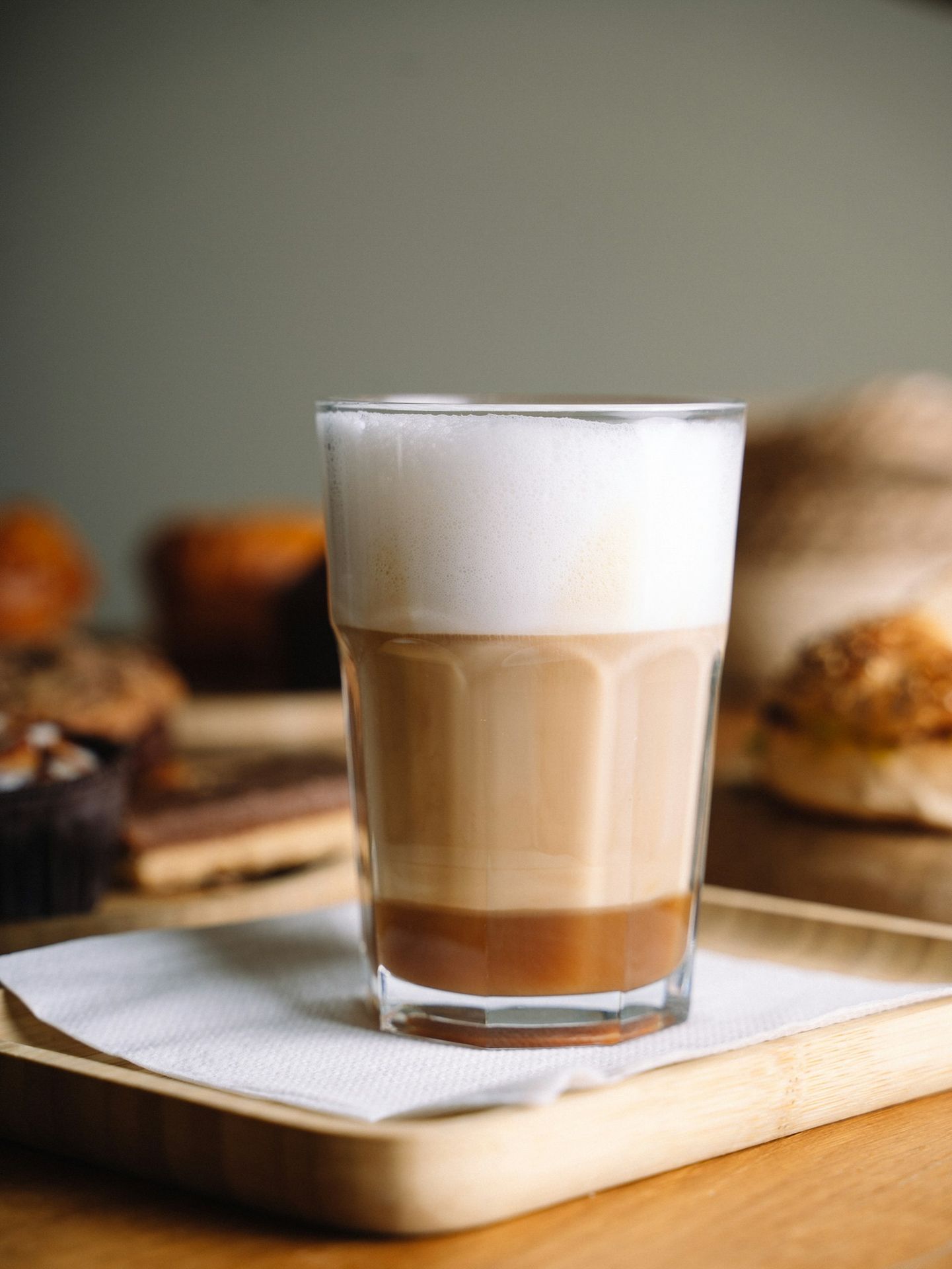 A glass of coffee sitting on top of a wooden table